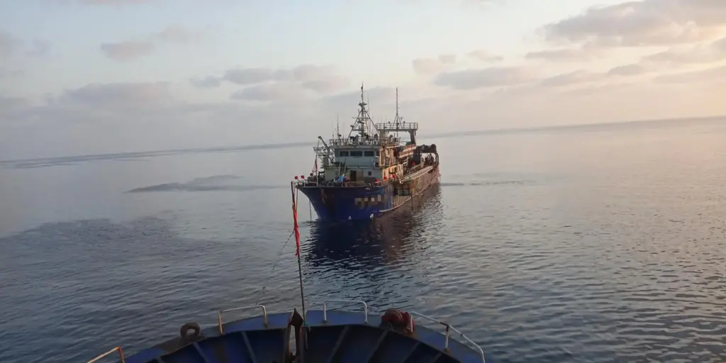 Fishing vessel being towed at sea