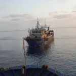 Fishing vessel being towed at sea