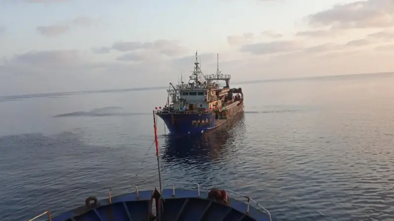 Fishing vessel being towed at sea