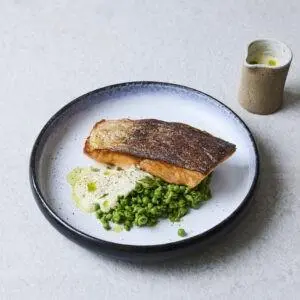 Crispy salmon with beurre blanc, crushed peas and parsley oil using salmon supplied by BAP-certified producer Hiddenfjord