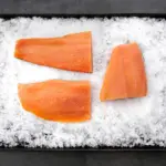 3 salmon fillets on ice